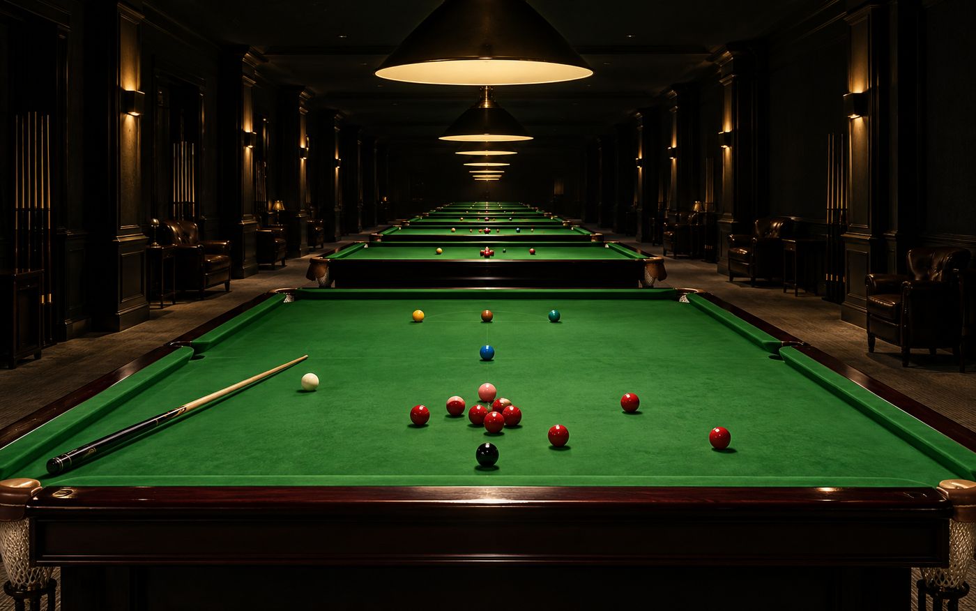 Six full-size snooker tables in a row down a hall, each under its own pendant lamp